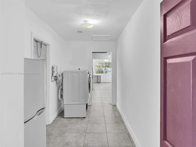 laundry area featuring independent washer and dryer, a textured ceiling, and light tile patterned flooring