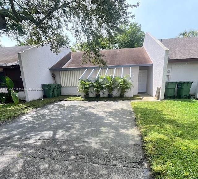 ranch-style home with a front lawn