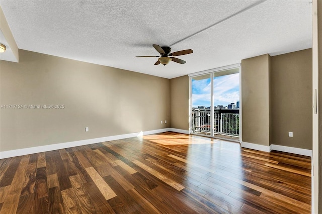 unfurnished room with wood-type flooring, a textured ceiling, expansive windows, and ceiling fan