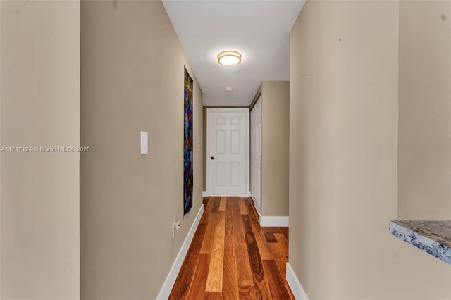 corridor with wood finished floors and baseboards