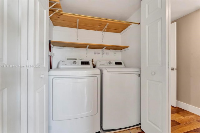 laundry room featuring light wood finished floors, laundry area, separate washer and dryer, and baseboards