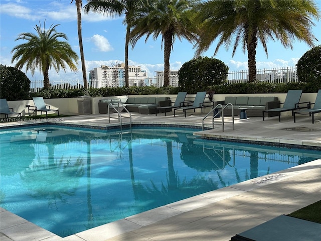 pool featuring fence, an outdoor living space, and a patio