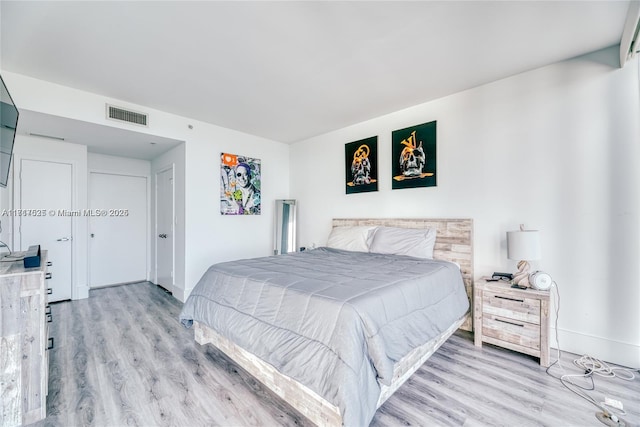 bedroom with light hardwood / wood-style floors and a closet