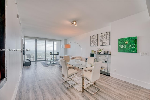 dining space with light hardwood / wood-style flooring and floor to ceiling windows