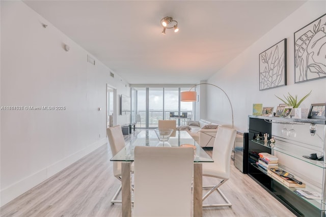 dining area featuring light hardwood / wood-style flooring and expansive windows