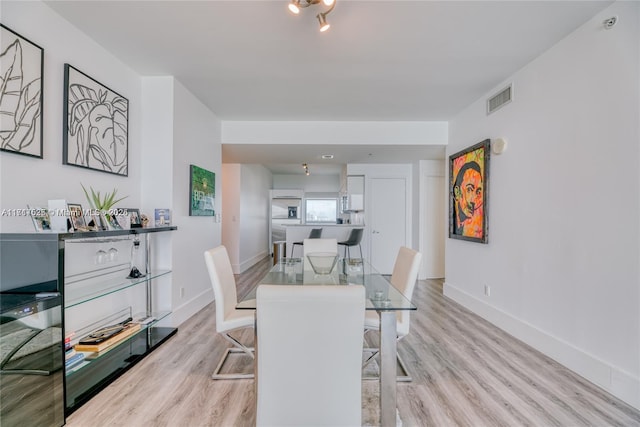 dining space with light hardwood / wood-style floors