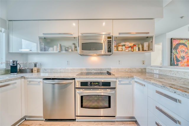 kitchen featuring light stone counters, white cabinetry, and appliances with stainless steel finishes