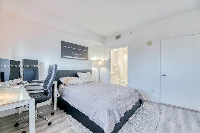 bedroom with ensuite bathroom and light hardwood / wood-style floors