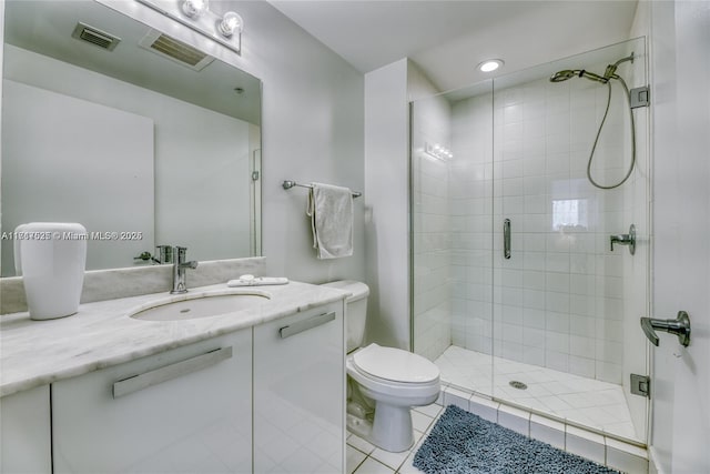 bathroom with tile patterned floors, toilet, an enclosed shower, and vanity