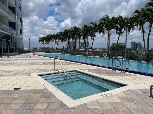 view of pool featuring a community hot tub and a patio