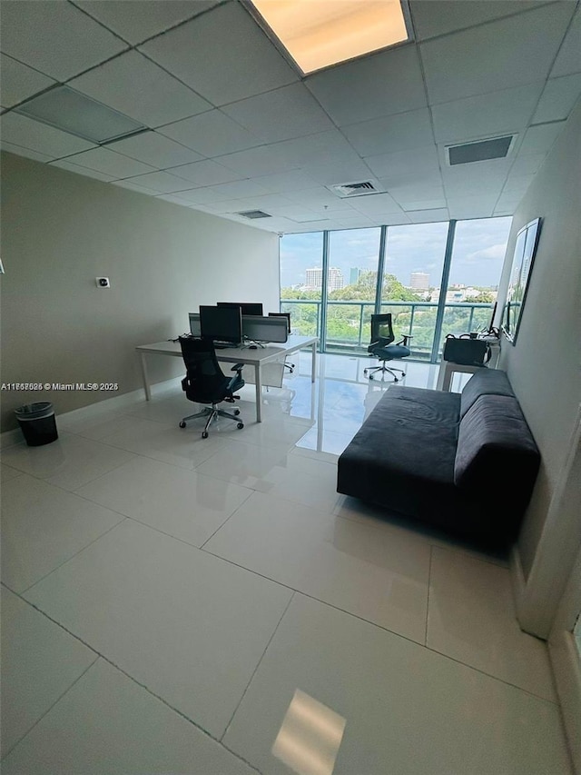 interior space with a paneled ceiling and floor to ceiling windows