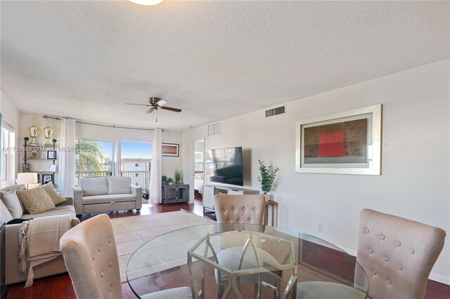 dining space featuring ceiling fan, hardwood / wood-style floors, and a textured ceiling