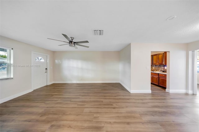 unfurnished living room with hardwood / wood-style floors and ceiling fan