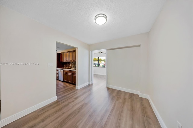 interior space featuring ceiling fan, a textured ceiling, and light hardwood / wood-style flooring