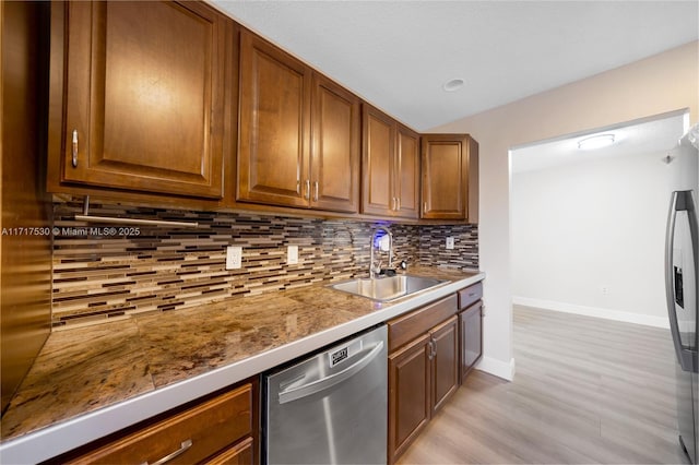 kitchen with decorative backsplash, sink, light hardwood / wood-style floors, and appliances with stainless steel finishes