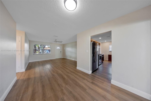 empty room featuring ceiling fan, dark hardwood / wood-style floors, and a textured ceiling