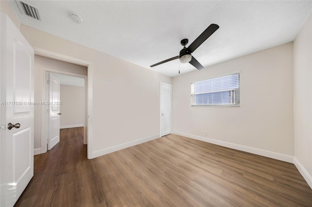 unfurnished room featuring ceiling fan and dark hardwood / wood-style flooring