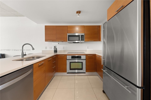 kitchen featuring sink, light tile patterned floors, stainless steel appliances, and kitchen peninsula