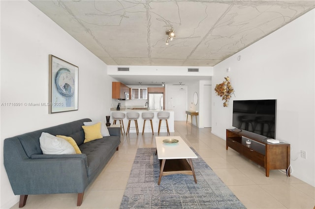 living room featuring sink and light tile patterned flooring