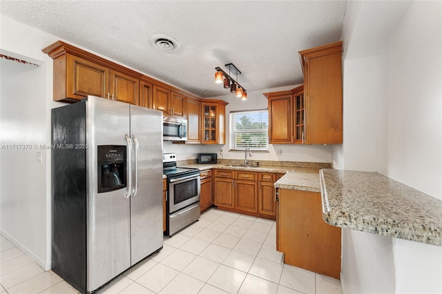 kitchen featuring kitchen peninsula, sink, a textured ceiling, and appliances with stainless steel finishes