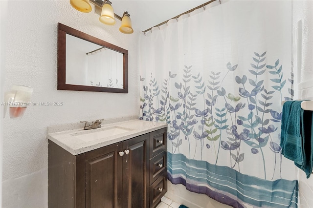 bathroom with tile patterned flooring, a shower with curtain, and vanity