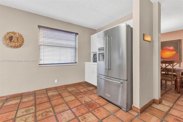 kitchen with high end fridge and a textured ceiling