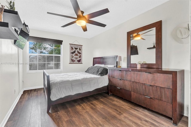 bedroom with a textured ceiling, ceiling fan, and dark wood-type flooring