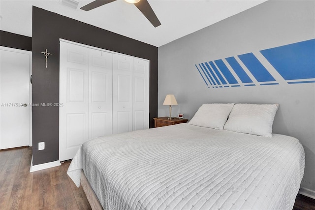 bedroom featuring ceiling fan, dark hardwood / wood-style floors, and a closet