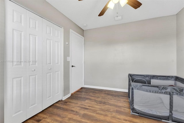 bedroom featuring a closet, dark hardwood / wood-style floors, and ceiling fan