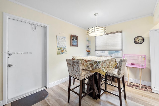 dining area with crown molding, cooling unit, and light wood-type flooring