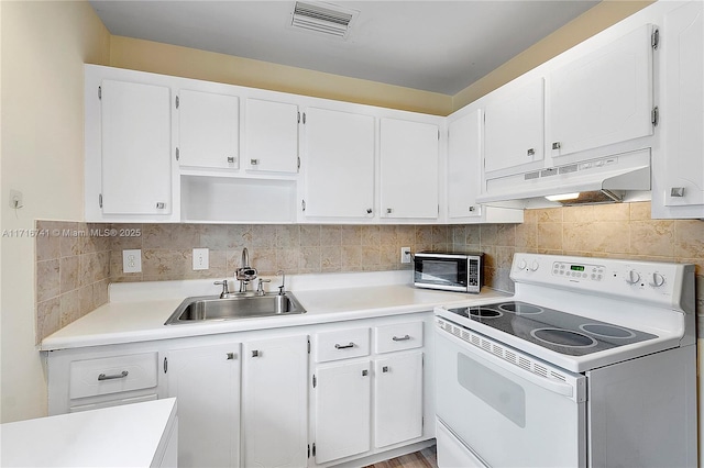 kitchen featuring white electric range oven, white cabinets, tasteful backsplash, and sink