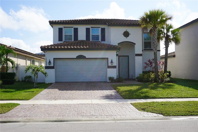 mediterranean / spanish home featuring a front lawn and a garage