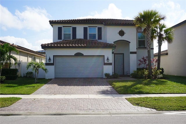 mediterranean / spanish house featuring a garage and a front lawn