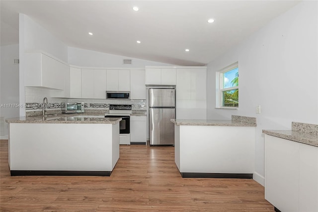 kitchen with kitchen peninsula, appliances with stainless steel finishes, and white cabinets