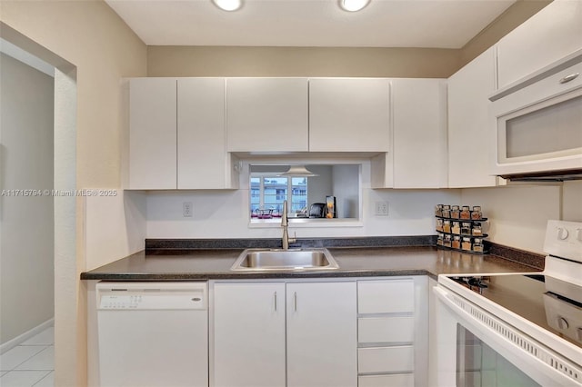 kitchen featuring light tile patterned floors, white appliances, white cabinetry, and sink