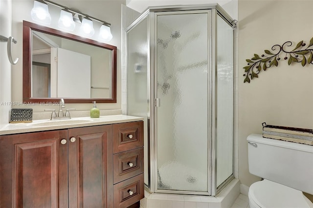 bathroom featuring tile patterned floors, vanity, toilet, and a shower with shower door