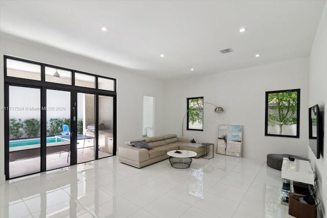 living room featuring light tile patterned floors, a wealth of natural light, and french doors