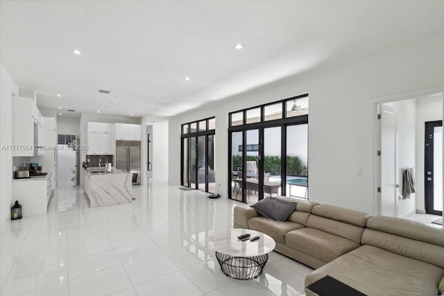 living room featuring sink and light tile patterned floors