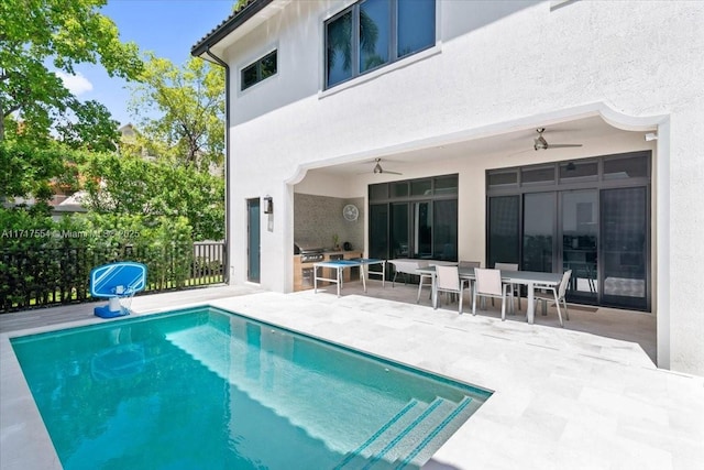 back of property featuring a patio, a fenced in pool, and ceiling fan