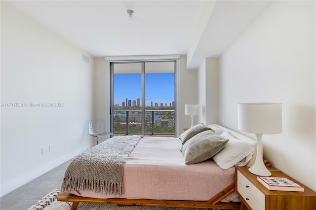 bedroom with access to exterior and a wall of windows