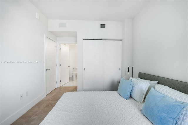 bedroom featuring ensuite bath and a closet