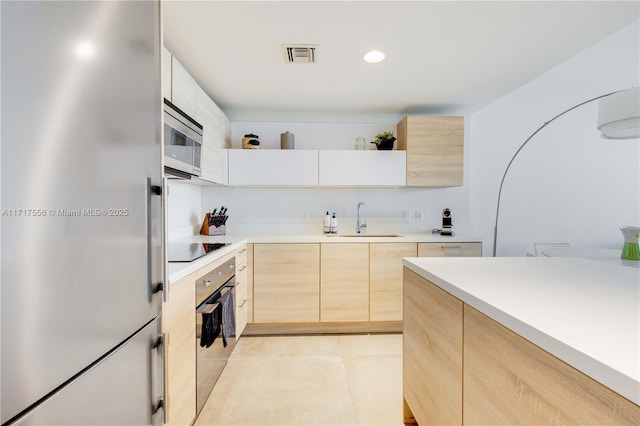 kitchen featuring sink, stainless steel appliances, light tile patterned flooring, light brown cabinetry, and white cabinets