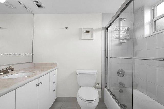 full bathroom with shower / bath combination with glass door, vanity, tile patterned floors, and toilet