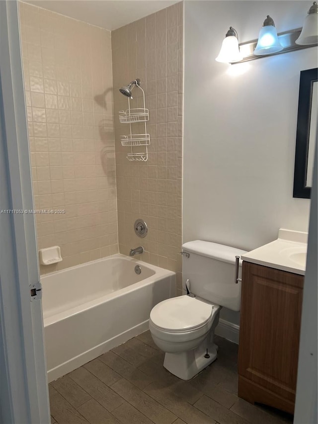 full bathroom with hardwood / wood-style flooring, tiled shower / bath combo, toilet, and vanity