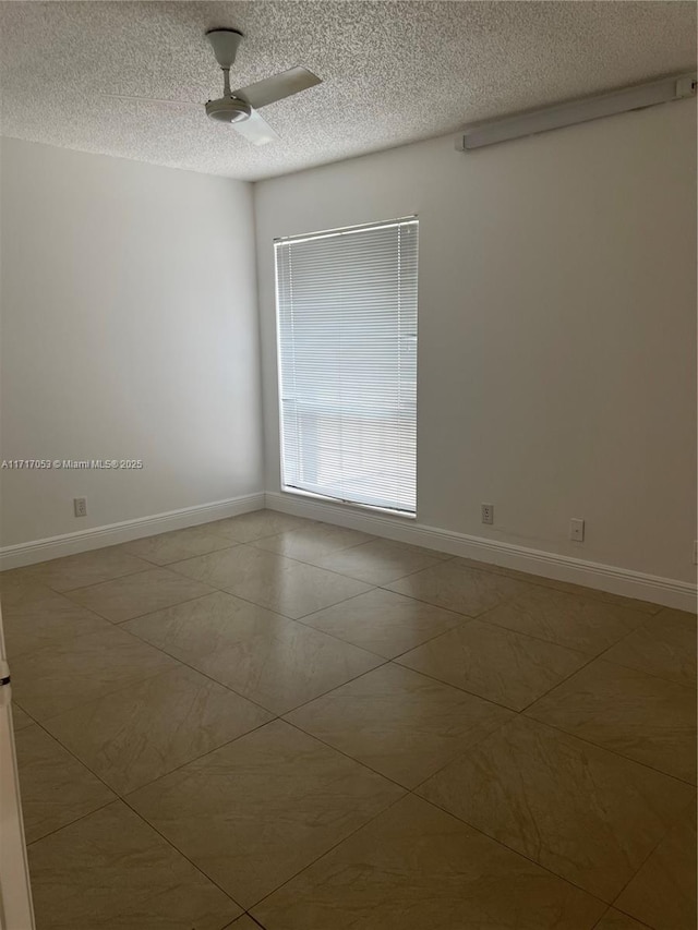 empty room with ceiling fan and a textured ceiling