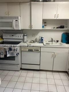 kitchen with white appliances, sink, and light tile patterned floors