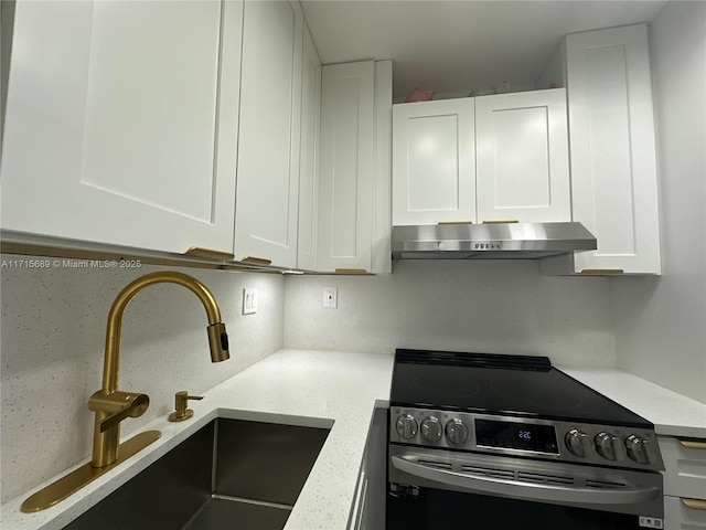 kitchen with white cabinets, decorative backsplash, stainless steel electric stove, and sink