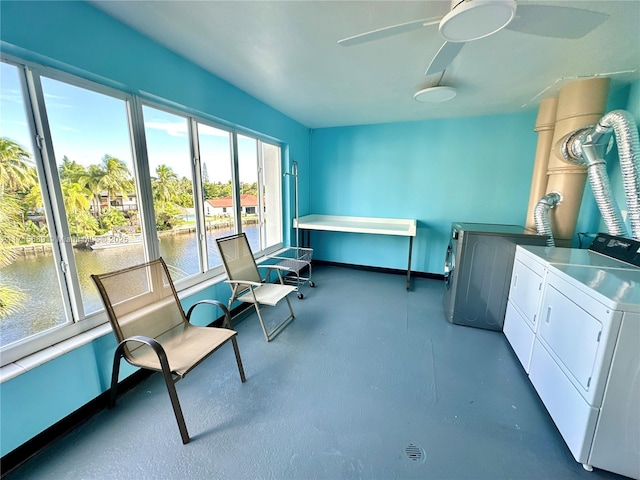 interior space with ceiling fan, a water view, a healthy amount of sunlight, and independent washer and dryer