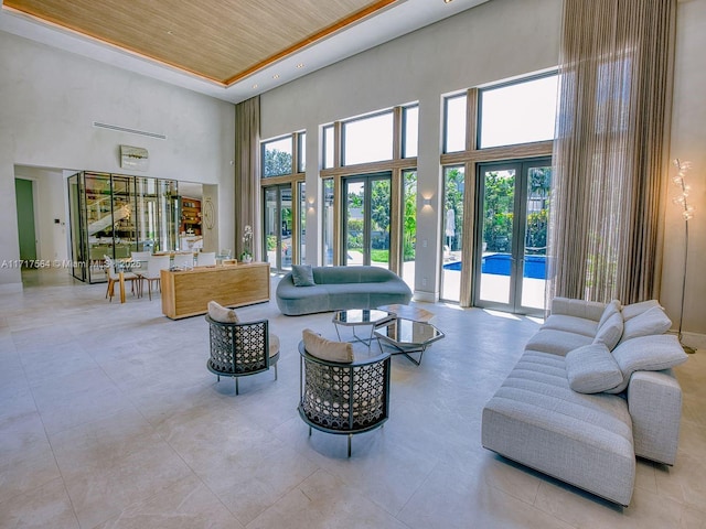 living room with wood ceiling, a high ceiling, and french doors