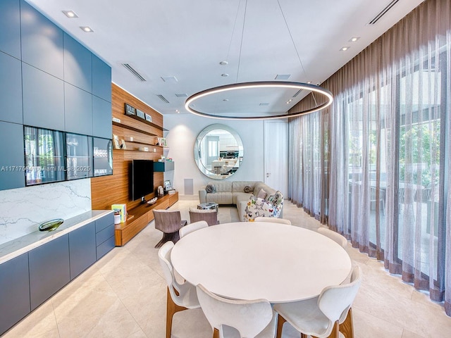 dining room with light tile patterned floors and wooden walls